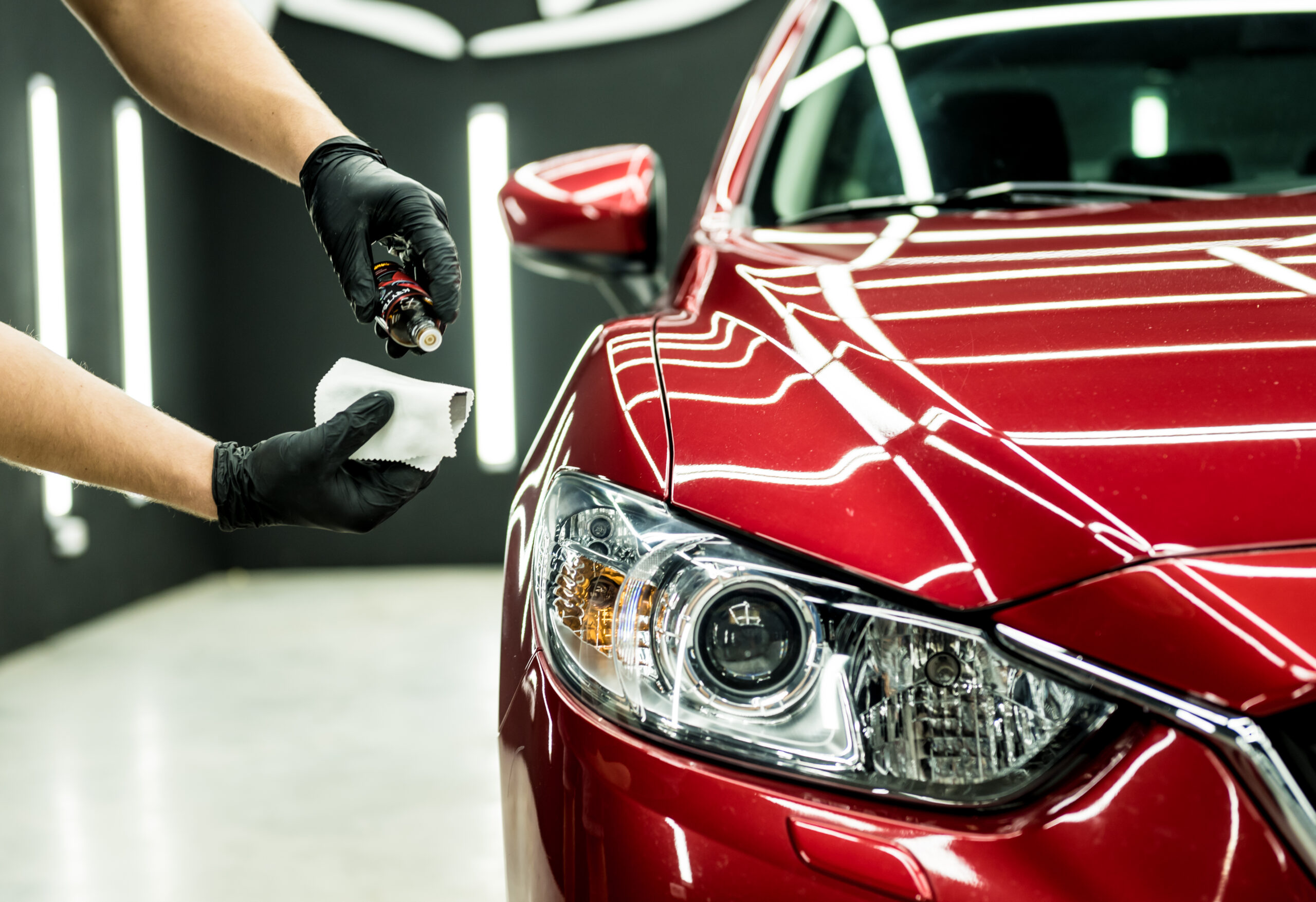 Car service worker applying nano coating on a car detail